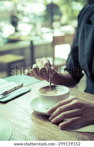 portrait image of woman stirring her coffee