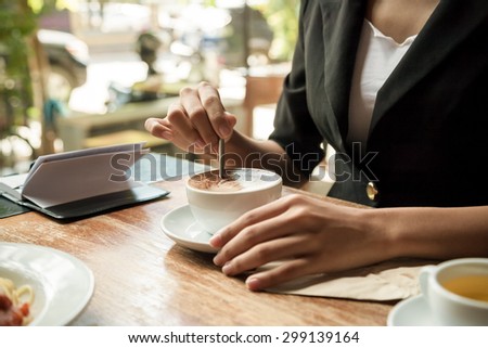 close up of woman stirring her coffee