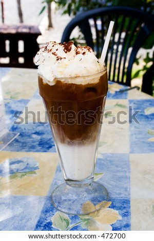 A glass with ice cappuccino and whipped cream