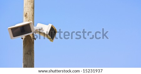 Speaker on a wooden pole against blue clear sky