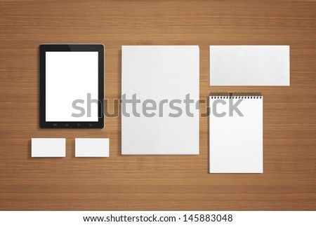 Blank Stationery set on the wooden background with soft shadows. Consist of Business cards, A4 letterheads, Notebook, Tablet PC and Envelopes.