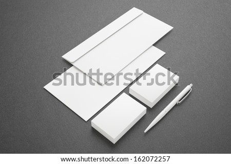 Blank Stationery Corporate ID set on dark background with soft shadows. Consist of Business cards, envelopes and pen.