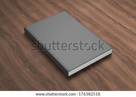 Book with black blank cover on wooden background
