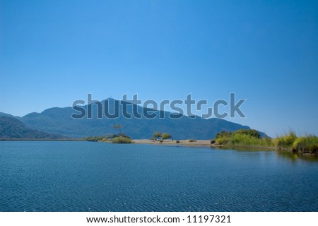 View on blue lagoon with mountains and deep blue sky on background
