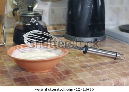 Photo of plate with confectionery cream and different kitchen ware around
