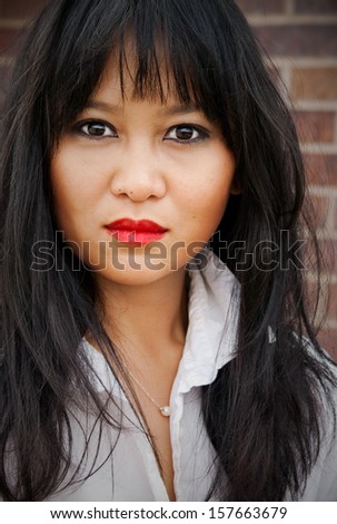 Portrait of Asian woman with bangs and white collared shirt.