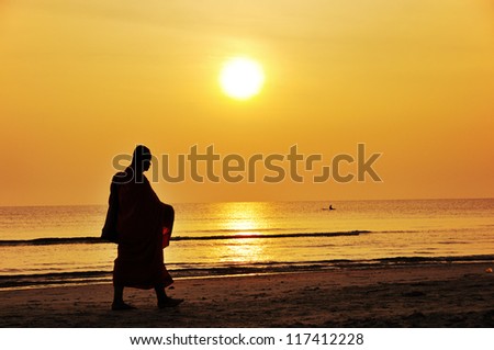 Silhouette of monk  walk on the beach , Huahin , Thailand