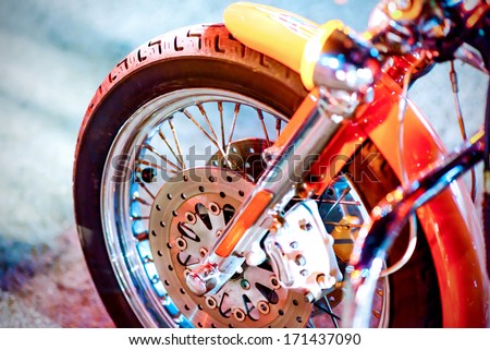 Closeup detail of a motorcycle\'s front wheel in traffic light