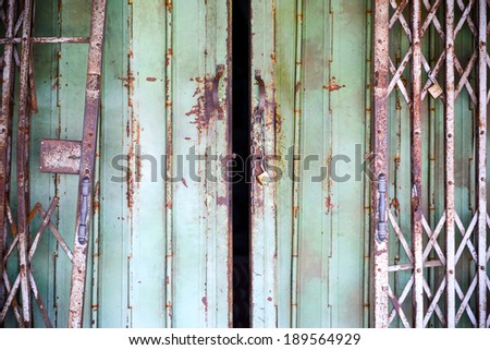 old rusty iron slide door with open lock