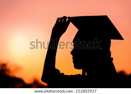 Silhouette of graduate woman in sunset