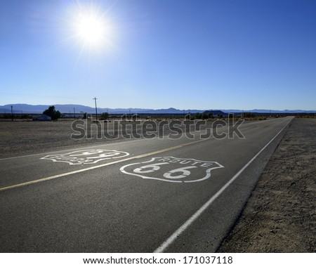 Historic route 66 sign painted on a desert highway in California.