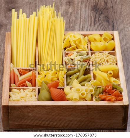 Various Raw Dry Pasta in Wooden Box closeup. Vertical View