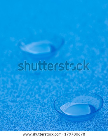 Pair of Contact Lenses with Water Droplets isolated on Blue background