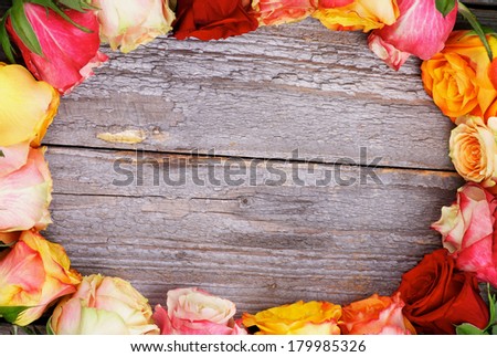 Ellipse Frame of Mixed Colorful Roses closeup on Rustic Wooden background