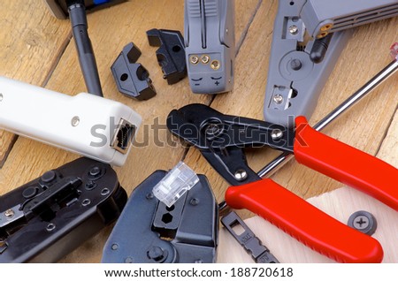 Arrangement of Computer Network Tools for Crimping, Cutting and Connecting closeup on Wooden background