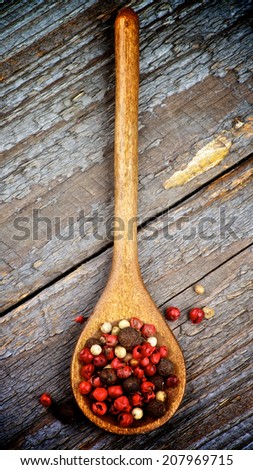 Mixed Red, Black and White Peppercorn in Wooden Spoon on Rustic Wooden background. Top View