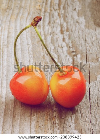 Two Sweet Maraschino Cherries isolated on Rustic Wooden background. Retro Styled