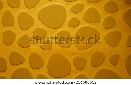 Background of Golden Sand Colored Droplet Shaped Stone on Cement Wall closeup