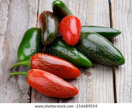 Heap of Red and Green Habanero and Jalapeno Chili Peppers isolated on Rustic Wooden background