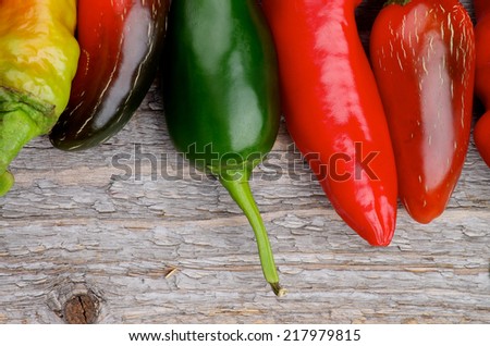 Border of Red and Green Habanero and Jalapeno Chili Peppers isolated on Rustic Wooden background