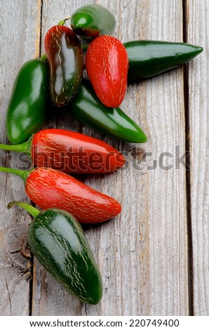 Stack of Red and Green Habanero and Jalapeno Chili Peppers isolated on Rustic Wooden background