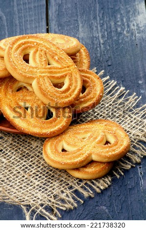 Stack of Homemade Shape Pretzel Sugar Cookies closeup on Sackcloth isolated on Dark Blue Wooden background