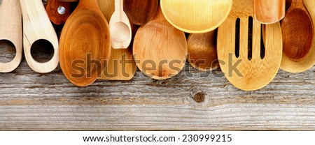 Border of Various Wooden Spoons and Cooking Utensils isolated on Rustic Wooden background. Horizontal View