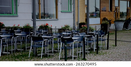 Contemporary Street Cafe with Steel Tables and Black Chairs on Paving Stone in Malmo, Sweden
