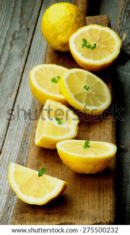 Ripe Raw Lemons Full Body and Halves on Wooden Cutting Board on Rustic background