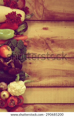 Frame of Various New Harvest Vegetables, Fruits, Roots, Edible Mushrooms and Berries closeup on Wooden background. Retro Styled