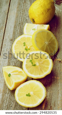 Ripe Raw Lemons Full Body, Halves and Slices In a Row on Rustic Wooden background