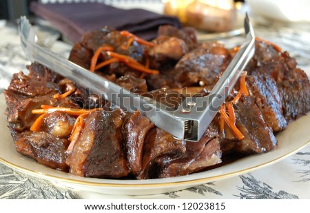Short ribs with carrot garnish on serving plate