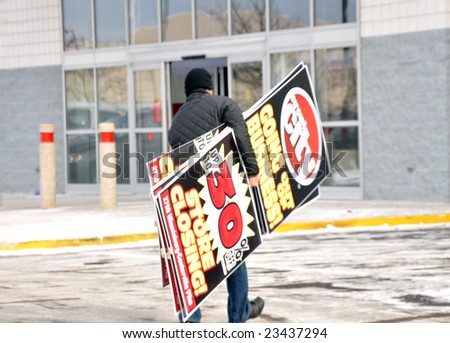 Dayton Ohio: January 17 2009. Employee carrying store closing signs at Circuit City. All stores of the second leading electronics retailer are closing. Relates to current economic times