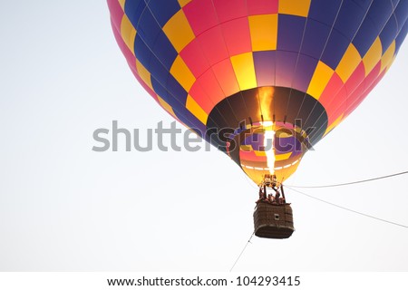 Silhouette hot air balloon landing with many people