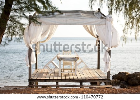 White chairs and table on a balcony with nice view to the sea