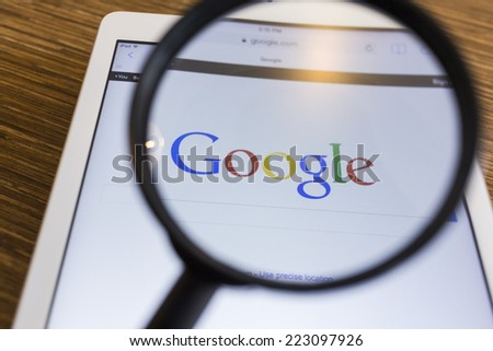 CHIANG MAI, THAILAND - SEPTEMBER 17, 2014: Magnifying glass of Google search page view on web browser Apple iPad Air device.