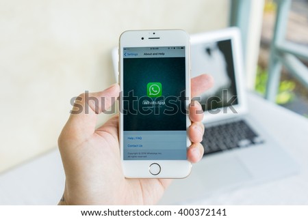 MAE HONG SON, THAILAND - MARCH 13, 2016: Man try to use social Internet service WhatsApp screen on blue background. iPhone 6S was created and developed by the Apple inc.