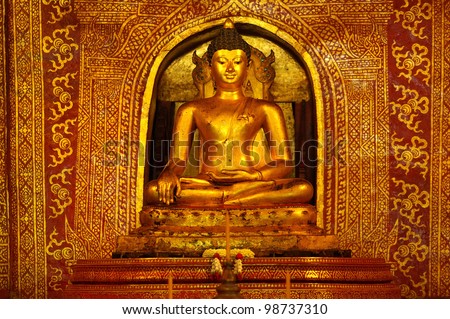 Golden Buddha statue (Phra Sihing Buddha) and art background in Wat Phra Singha, Chiang Mai Province, Thailand.
