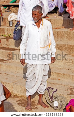 VARANASI, INDIA - APRIL 23: Unidentified hindu man looking at the people taking ritual bath in the river Ganga on April 23, 2011 in the holy city of Varanasi, India. The ritual bath is held every day.