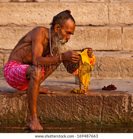 VARANASI, INDIA - APRIL 24: Unidentified man washes his clothes in the river Ganga on April 24, 2011 in the holy city of Varanasi, India. The holy ritual of washing and bathing is held every day.