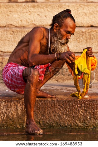 VARANASI, INDIA - APRIL 24: Unidentified man washes his clothes in the river Ganga on April 24, 2011 in the holy city of Varanasi, India. The holy ritual of washing and bathing is held every day.