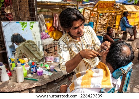 DELHI - APR 16: Barber working in his small shop on April 16, 2011 in Delhi, India. Delhi is the largest urban agglomeration in India by population, and the 4th most populous city on the planet.