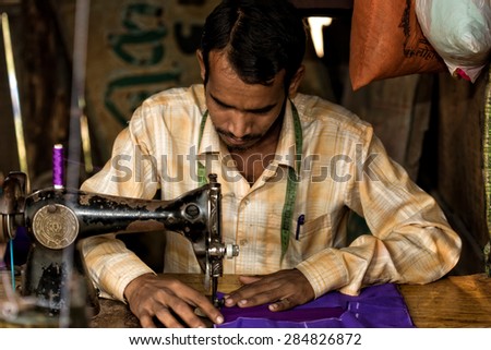 RAXAUL - NOV 7: Indian man working in his sewing workshop on Nov 7, 2013 in Raxaul, Bihar state, India. Bihar is one of the poorest states in India. The per capita income is about 300 dollars.