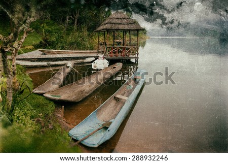 Vintage style image of traditional boats at Lake Bunyonyi in Uganda, Africa, at the borders of Uganda, Congo and Rwanda, not far from the Bwindi National Park, home of the last mountain gorillas