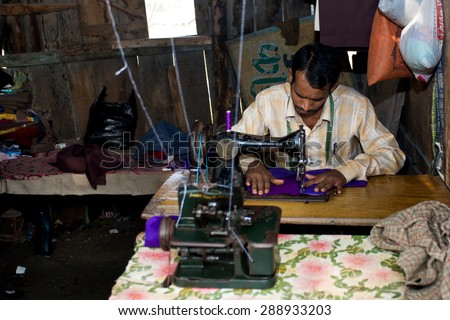 RAXAUL - NOV 7: Indian man working in his sewing workshop on Nov 7, 2013 in Raxaul, Bihar state, India. Bihar is one of the poorest states in India. The per capita income is about 300 dollars.