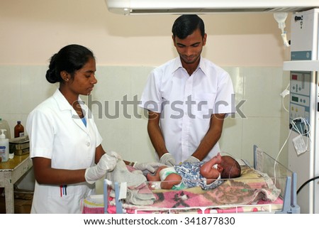 RAXAUL, INDIA - OCT 24: Unidentified Indian nurses with a newborn baby in a local hospital on Oct 24, 2011 in Raxaul, Bihar, India. Bihar is one of the poorest states in India.