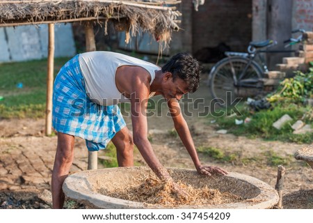 RAXAUL, INDIA - NOV 9: Unidentified Indian man working at a buffalo farm on Nov 9, 2013 in Raxaul, Bihar, India. Bihar is one of the poorest states in India. The per capita income is about 300 dollars