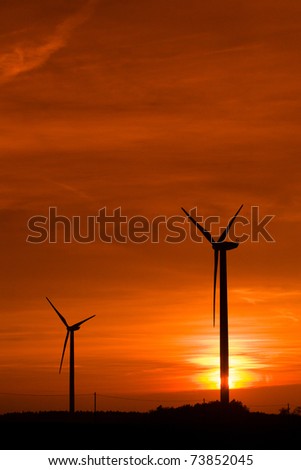 Silhouette of wind power station at sunset