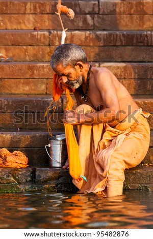 VARANASI, INDIA - APRIL 24: Unidentified man taking ritual bath in the river Ganga on April 24, 2011 in the holy city of Varanasi, India. The holy ritual bath is held every day.