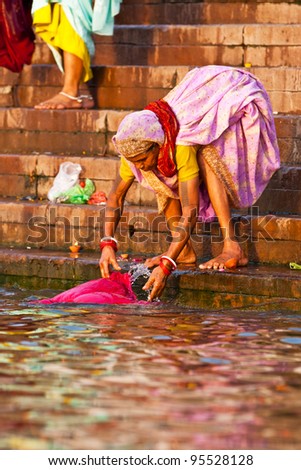 VARANASI, INDIA - APRIL 24: Unidentified hindu men watching the ritual bath in the river Ganga on April 24, 2011 in the holy city of Varanasi, India. The holy ritual bath is held every day.